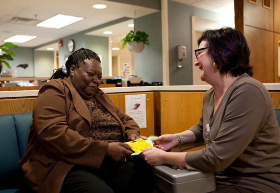 Two smiling women conversing in a waiting room