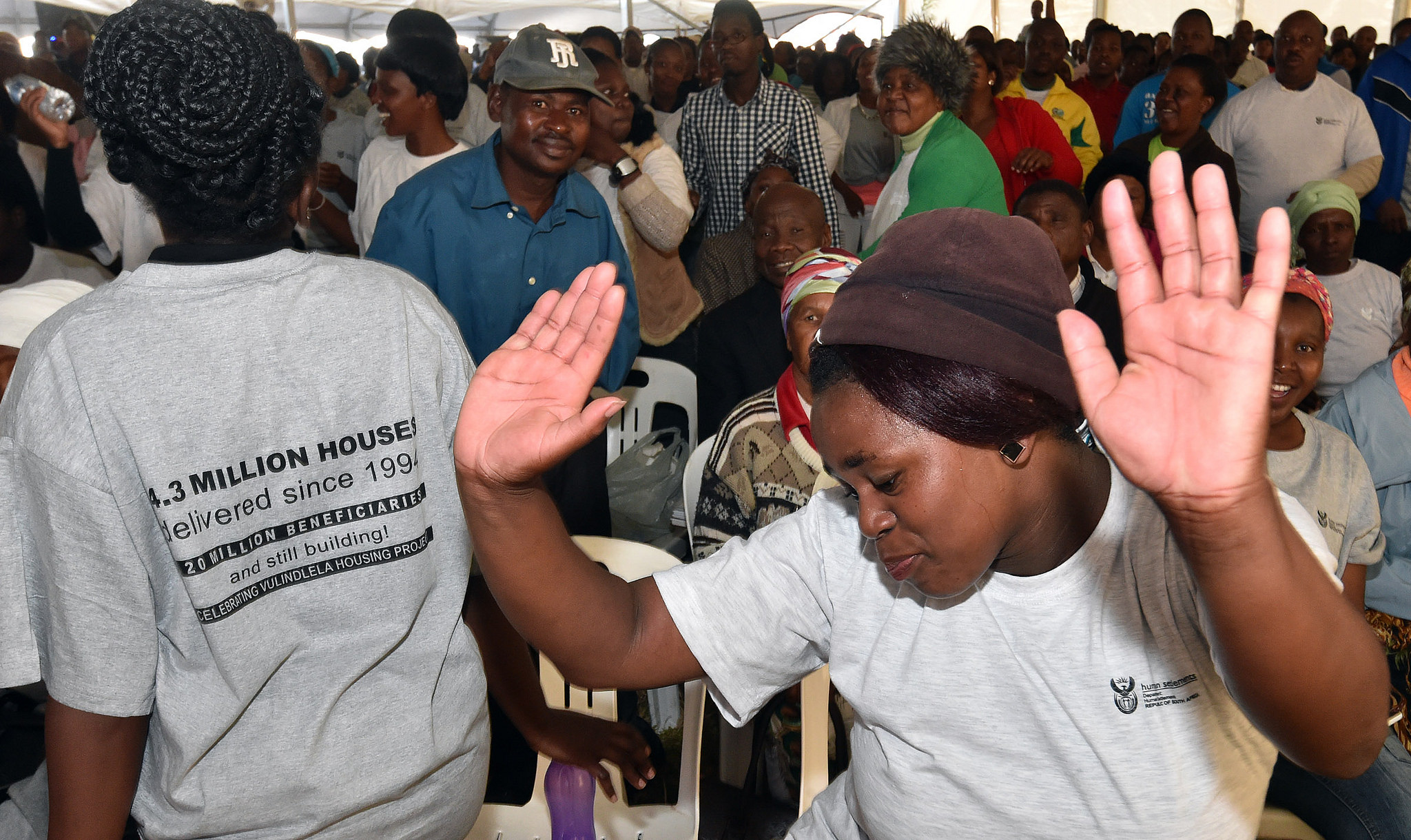 South African woman with hands in the air dancing at community event