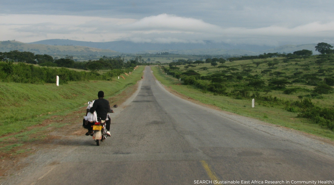 Sub-Saharan local riding a motorbike on an open road