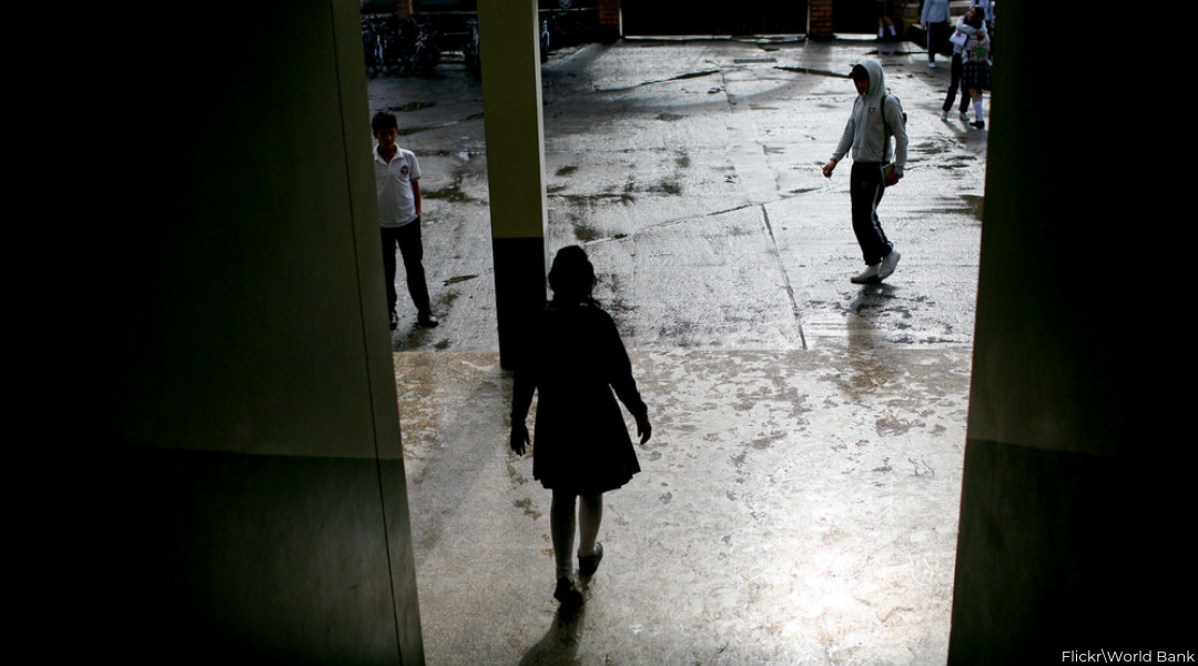 Back of girl walking out with two boys in front of her in high school