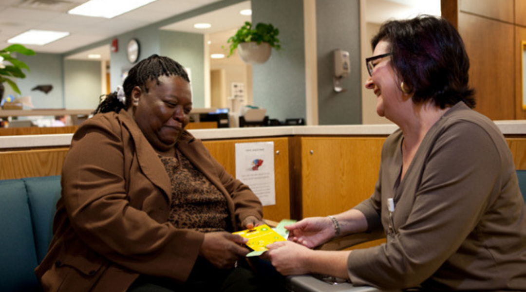 Patient living with HIV smiling with smiling primary care provider