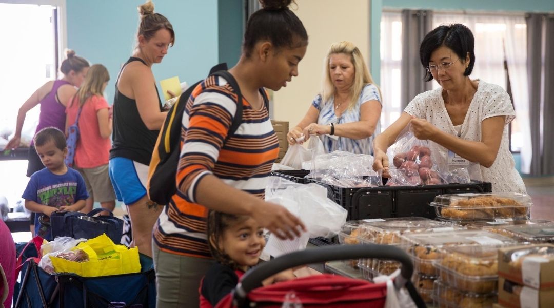 A woman visiting a local food bank with her children