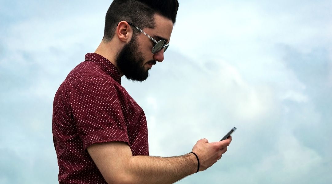 A young man looks at his smart phone