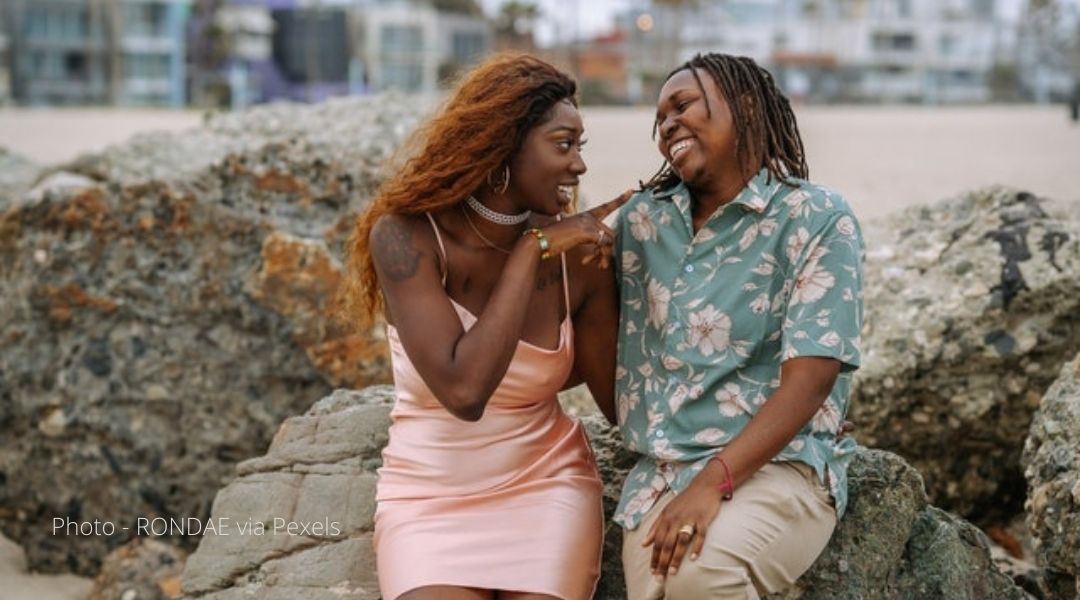 A photo of a couple sitting on a beach enjoying each others company