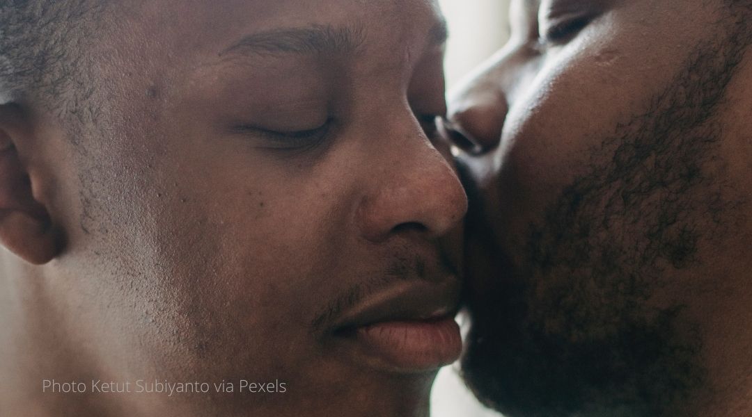 Two black men in a close embrace