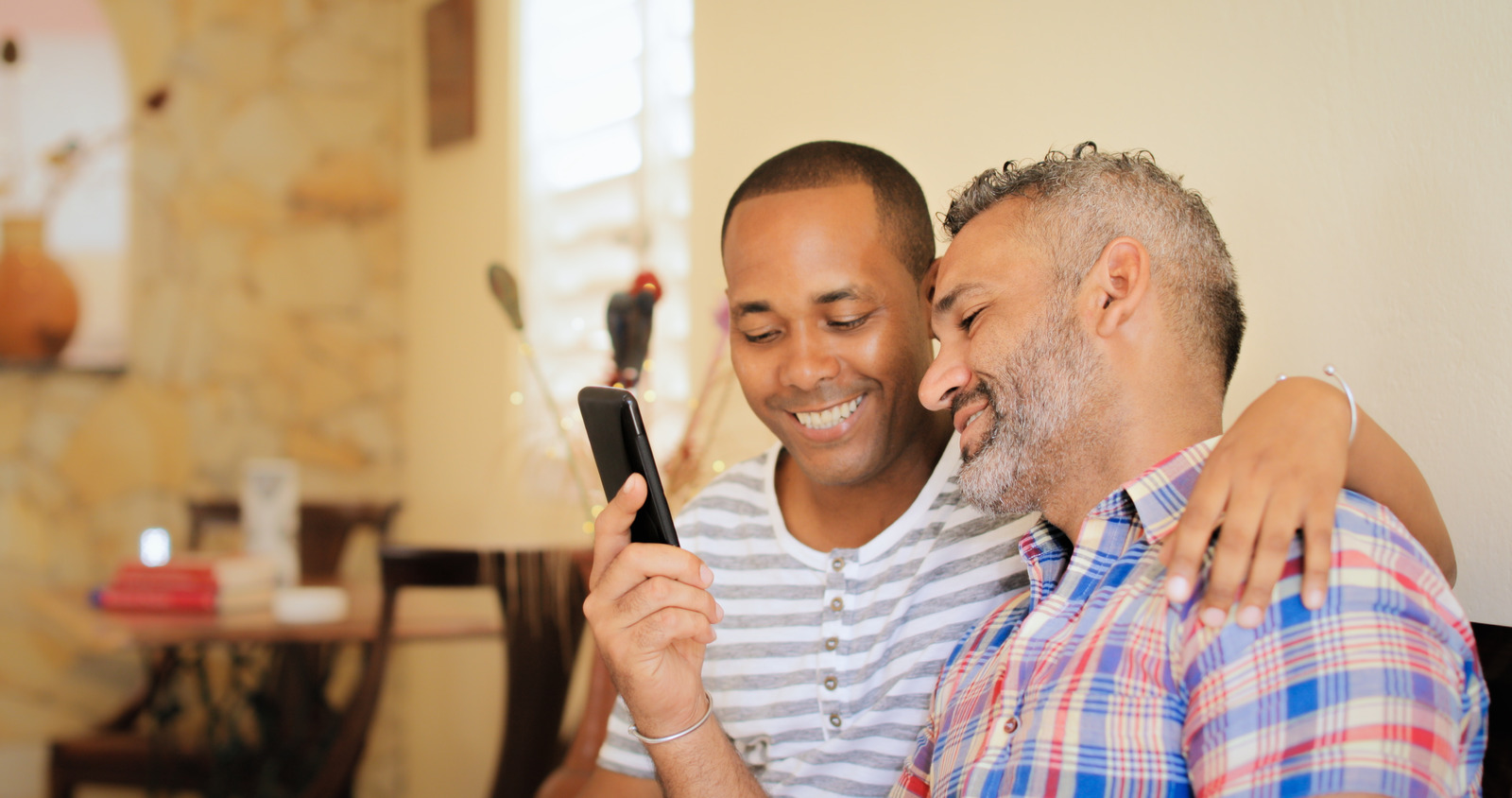 A smiling couple stares at a smartphone screen