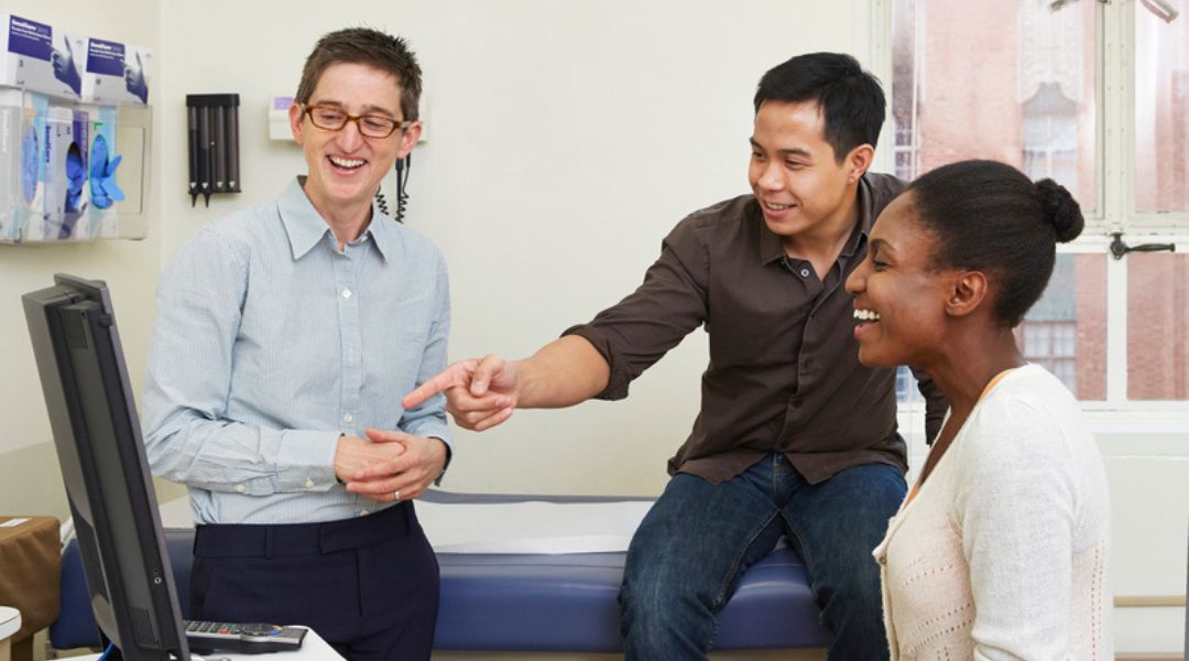 A telehealth conversation with three health providers talking to a patient on a laptop