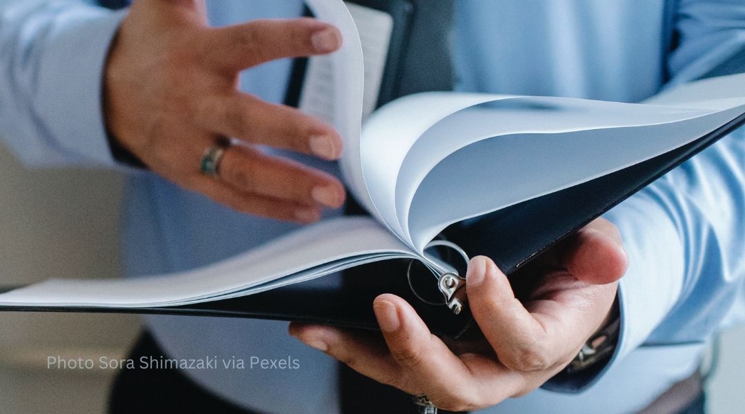 A person turning the page of a binder